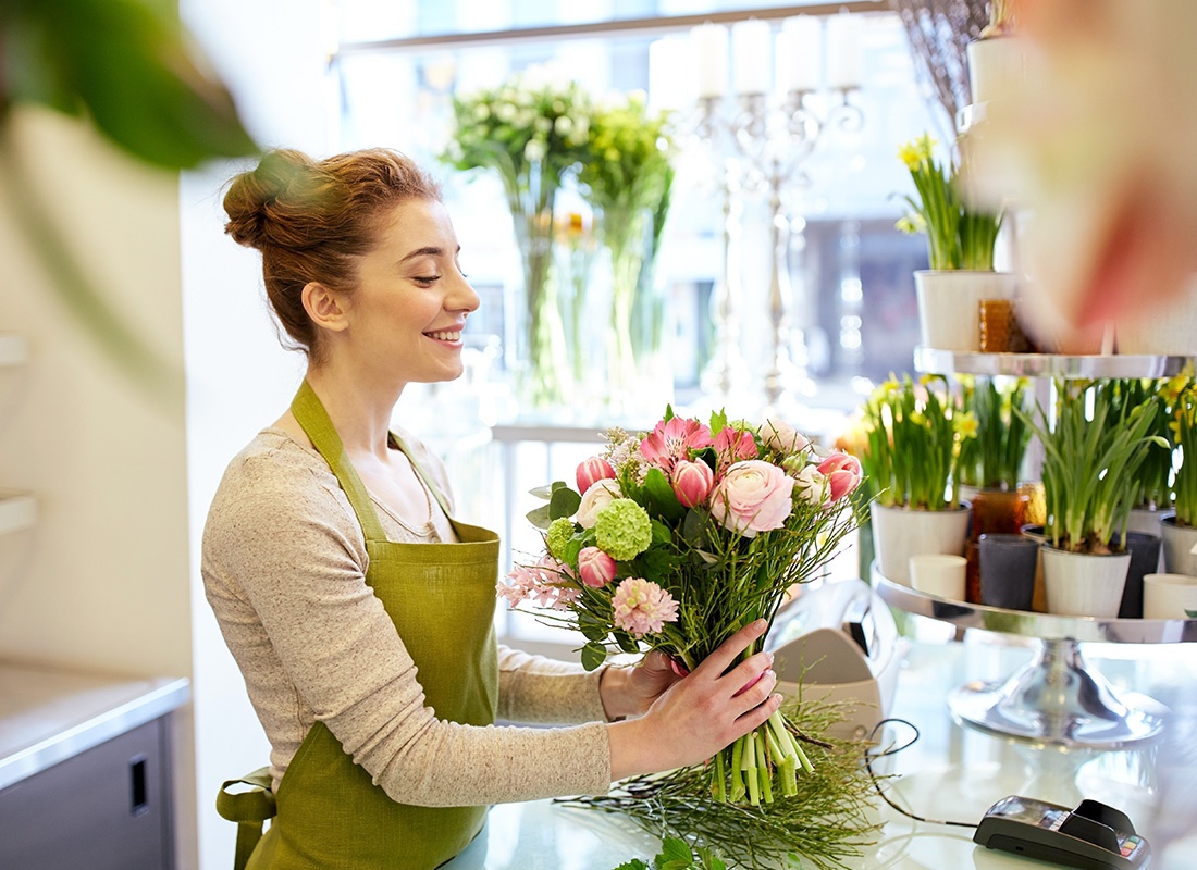Floral Shop Insurance - Smiling Florist Arranging a Bouquet at a Flower Shop